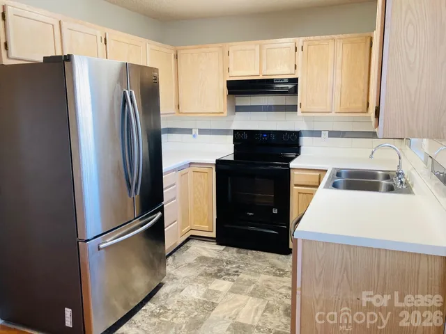 a kitchen with a refrigerator sink and cabinets
