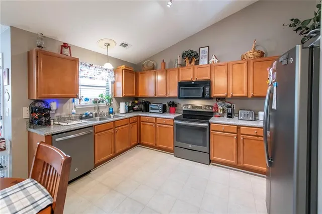a kitchen with granite countertop a stove top oven a sink dishwasher and a microwave oven with cabinets
