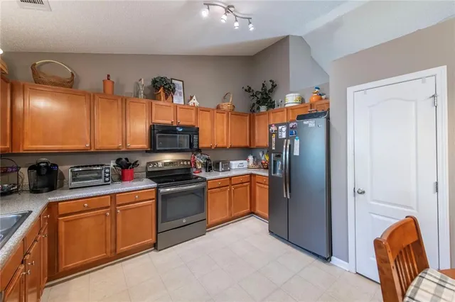 a kitchen with stainless steel appliances granite countertop a refrigerator and a sink