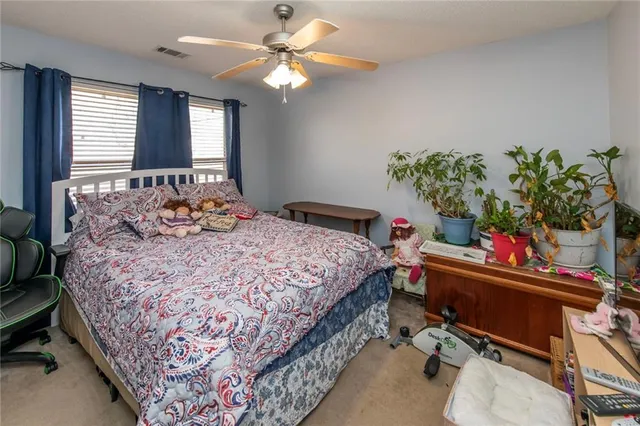 a bedroom with a bed table chair and a window