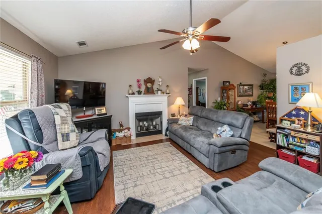 a living room with furniture a flat screen tv and a fireplace