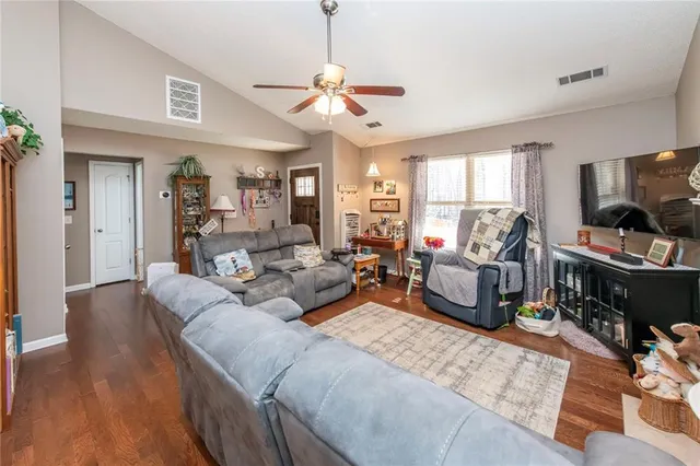 a living room with furniture flat screen tv and a large window