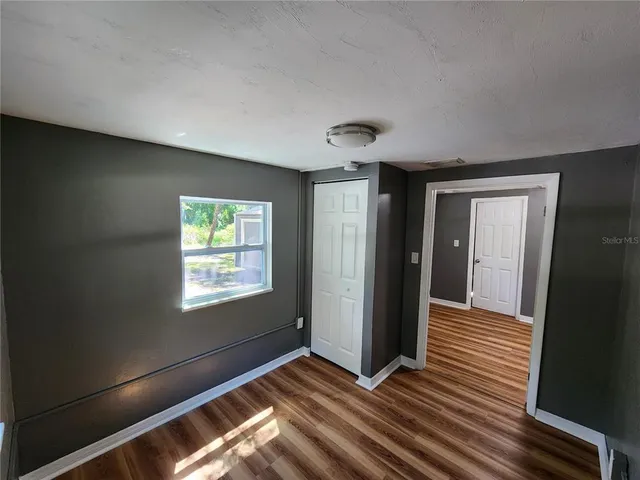 a view of empty room with window and ceiling fan