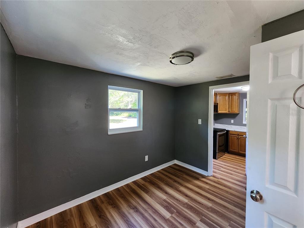 106 Southwest 6th Street Micanopy, FL 32667 - Photo 40 of 62 a view of an empty room with wooden floor and a window