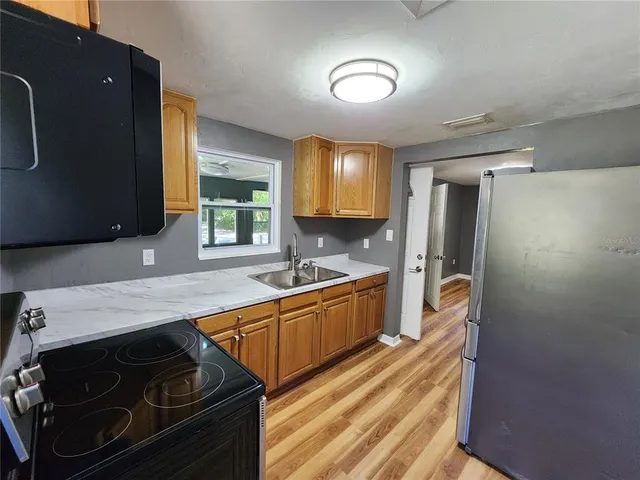 a kitchen with wooden floor and a sink