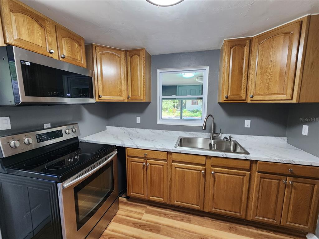 106 Southwest 6th Street Micanopy, FL 32667 - Photo 50 of 62 a kitchen with stainless steel appliances granite countertop a sink stove and microwave