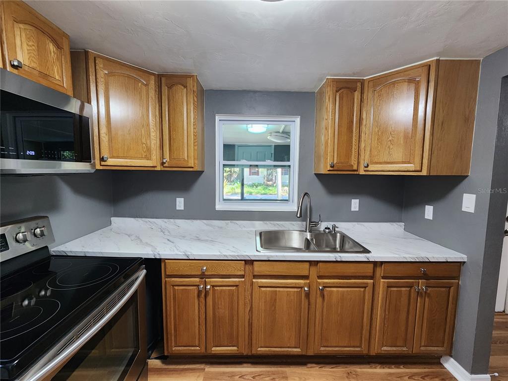 106 Southwest 6th Street Micanopy, FL 32667 - Photo 62 of 62 a kitchen with stainless steel appliances granite countertop wooden cabinets a sink and a stove