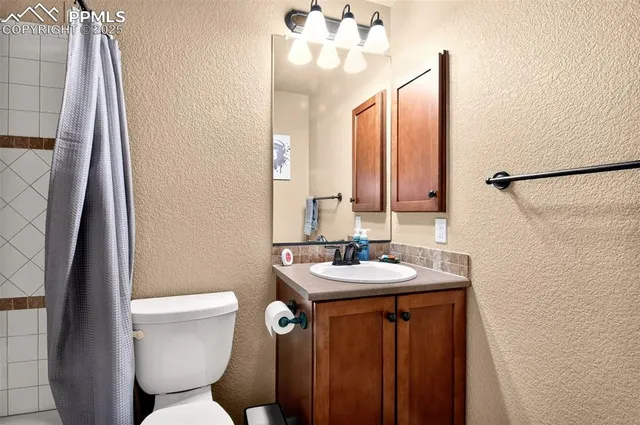 a bathroom with a sink a toilet a mirror and shower