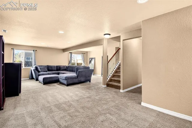 a living room with furniture and a ceiling fan
