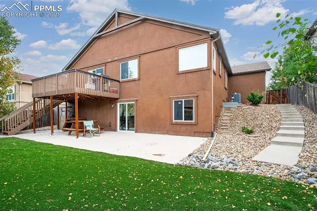 a view of a house with wooden fence and a bench