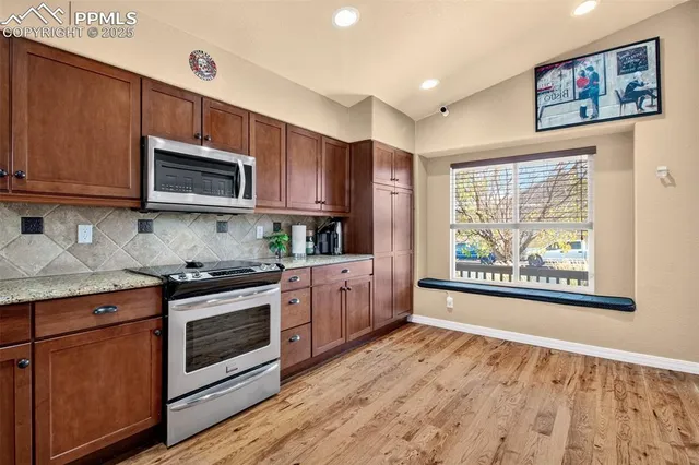 a kitchen with stainless steel appliances granite countertop a stove a microwave a sink and cabinets