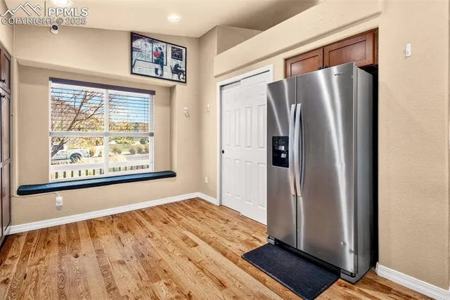 a view of a kitchen with wooden floor and a refrigerator