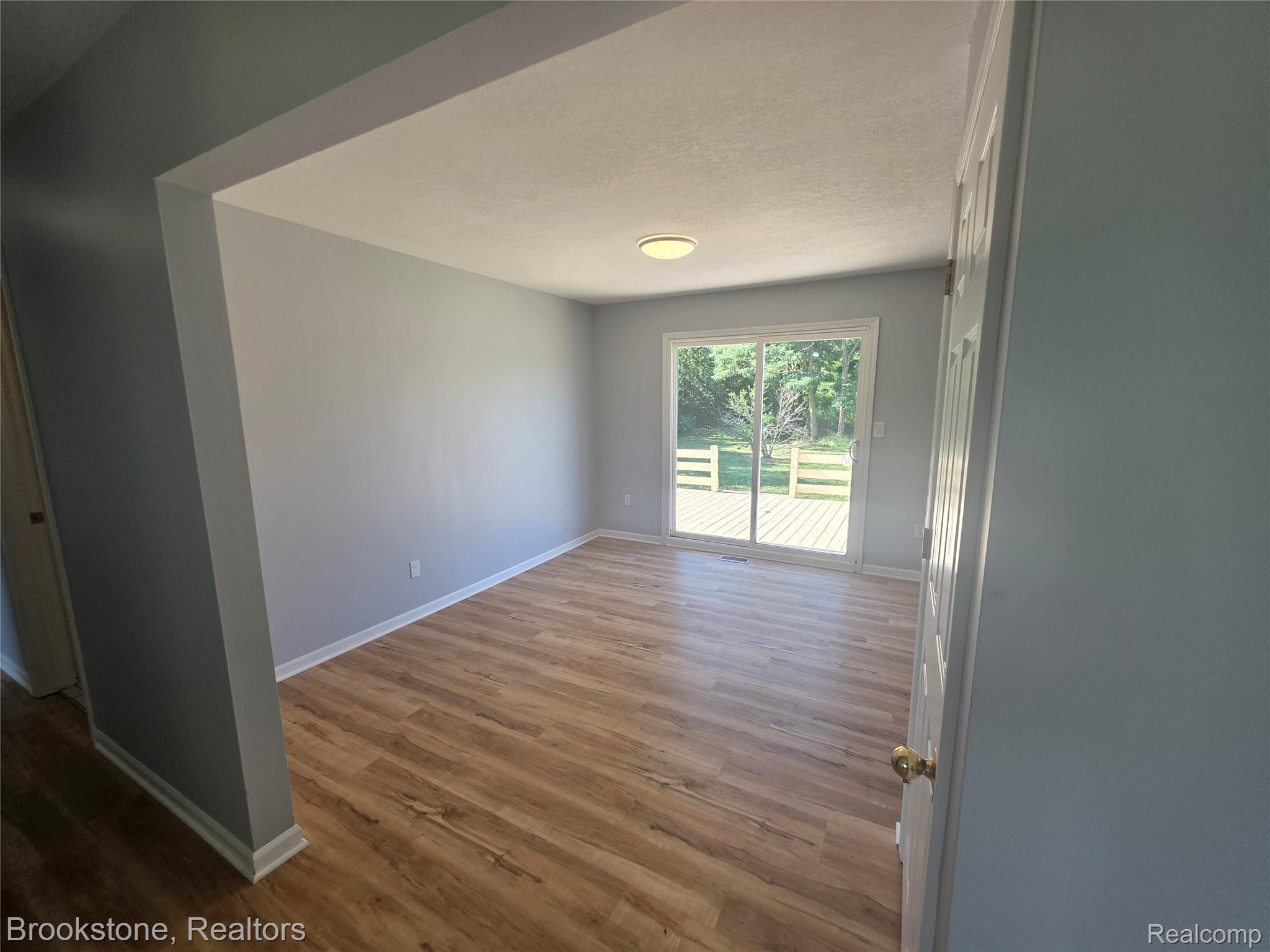 6428 Cook Road Swartz Creek, MI 48473 - Photo 5 of 12 Open-concept interior featuring wood-finish flooring, light gray wall paint, and a sliding glass door