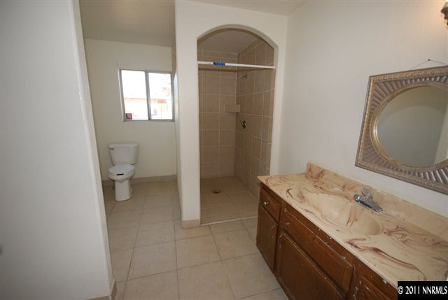 1231 East 9th Street Reno, NV 89512 - Photo 9 of 13 a spacious bathroom with a granite countertop sink a toilet and a mirror