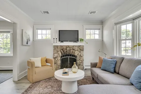 a living room with furniture a window and a fireplace