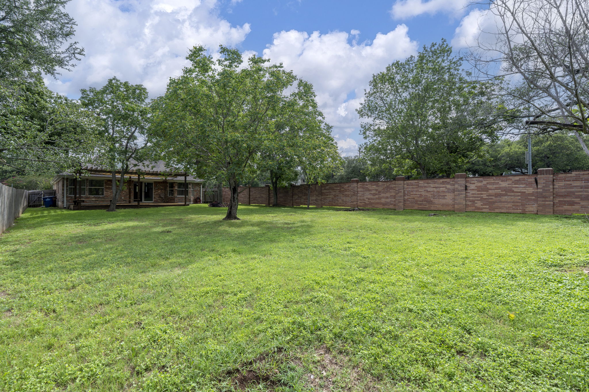 7172 Ridge Oak Road Austin, TX 78749 - Photo 12 of 40 A verdant backyard offers ample space for outdoor enjoyment and recreation.