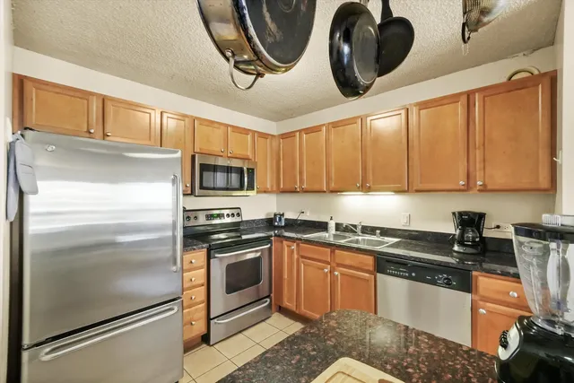a kitchen with stainless steel appliances granite countertop a refrigerator a stove top oven a sink and dishwasher