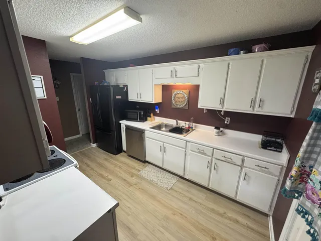 a kitchen with a sink a refrigerator and cabinets