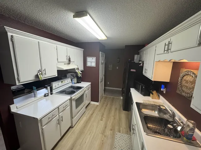 a kitchen with a sink stove and cabinets