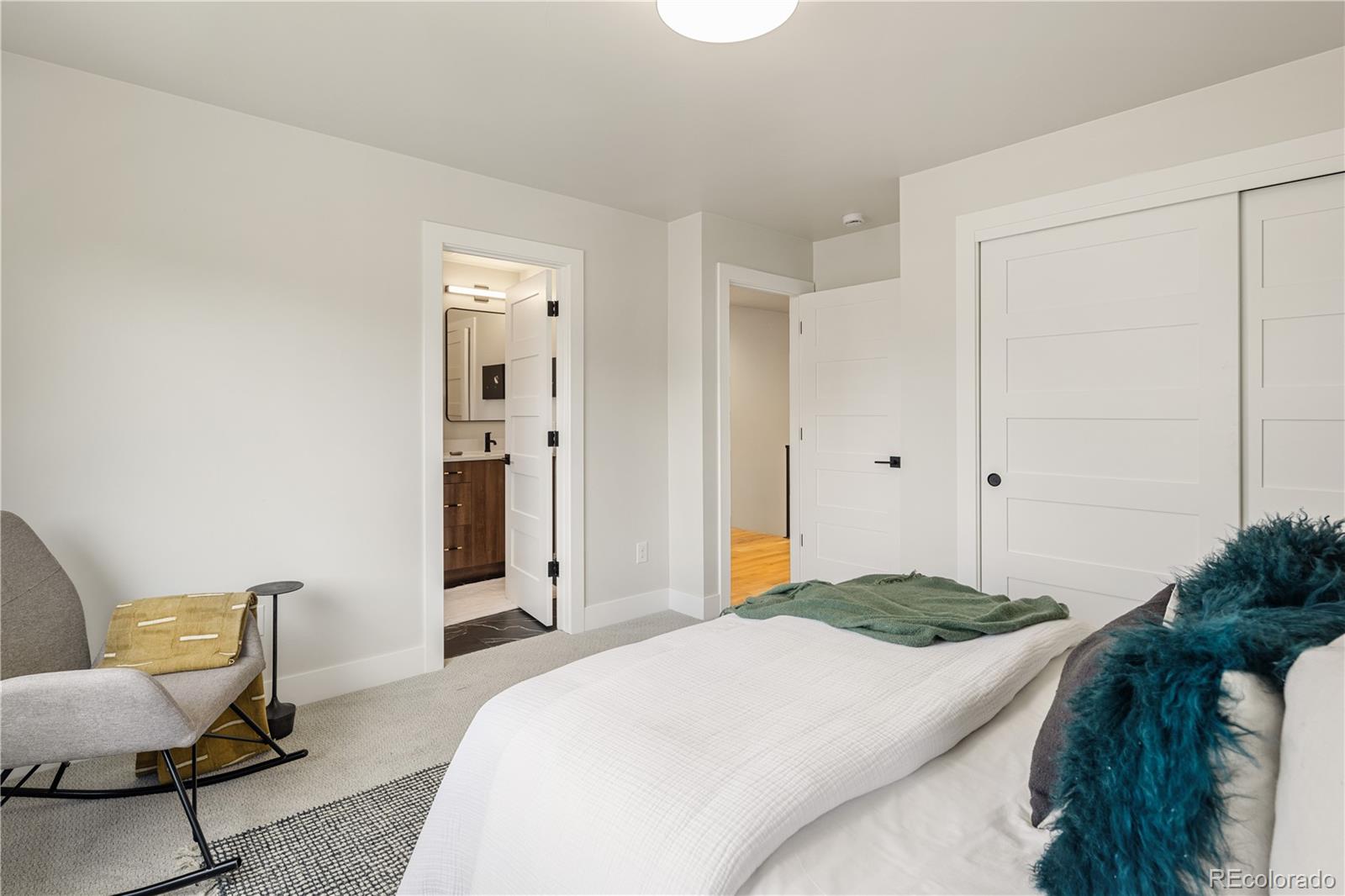 2143 High Street Denver, CO 80205 - Photo 25 of 43 a bedroom with a bed and a chair