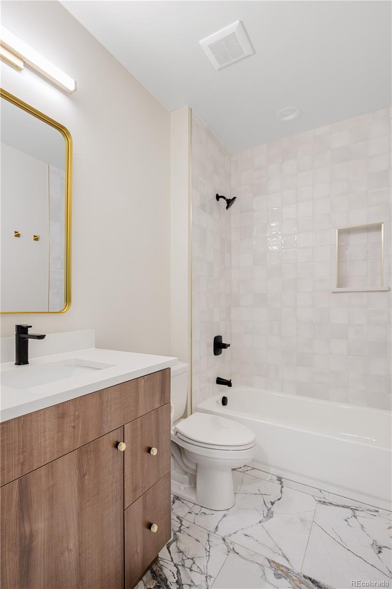 2143 High Street Denver, CO 80205 - Photo 33 of 43 a bathroom with a sink a toilet and a mirror