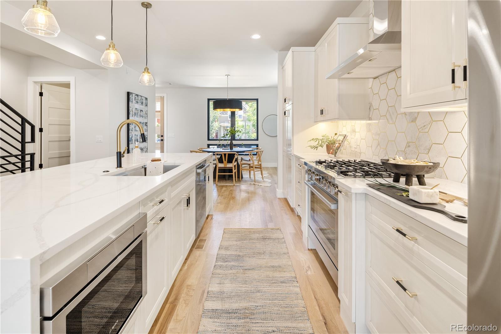 2143 High Street Denver, CO 80205 - Photo 8 of 43 a kitchen with kitchen island granite countertop lots of counter top space and stainless steel appliances
