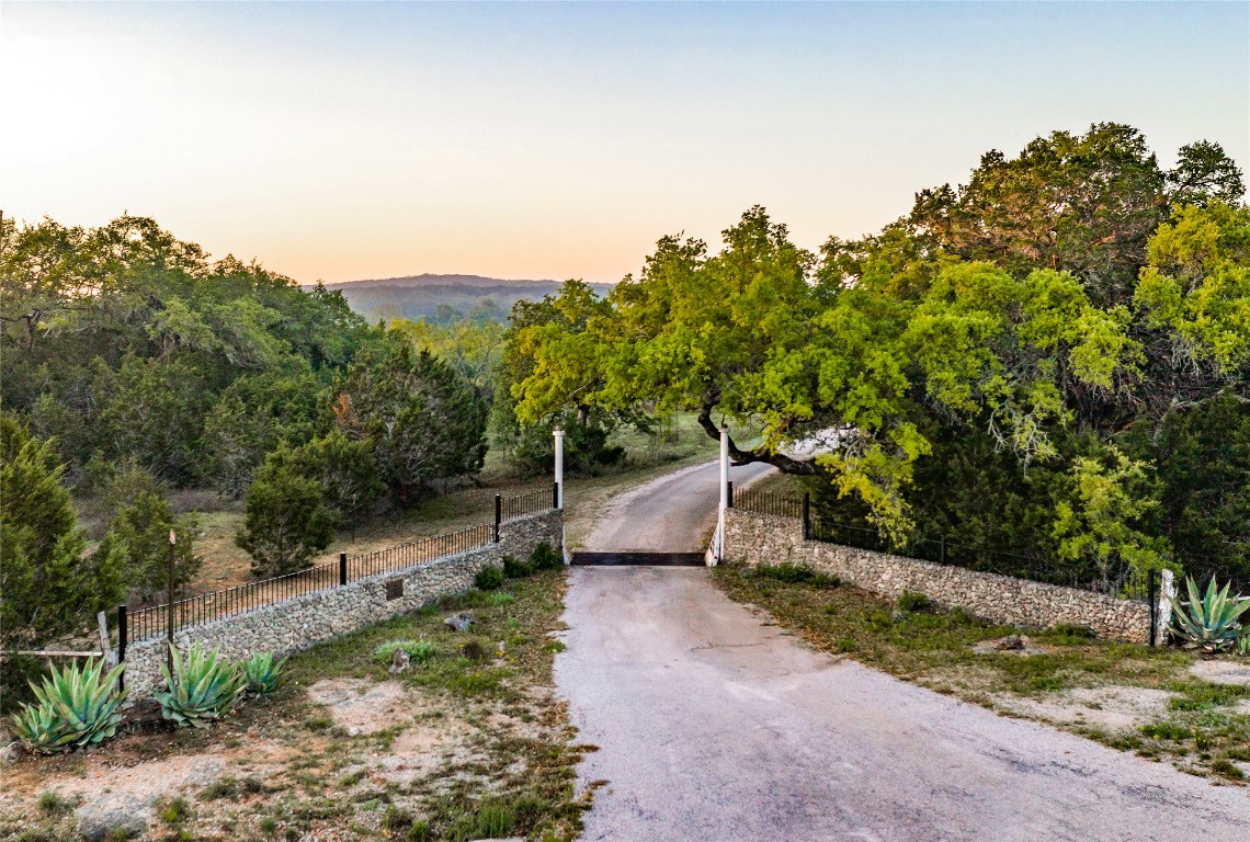 892 Baird Ranch Road Johnson City, TX 78636 - Photo 6 of 22 View of property entry featuring asphalt driveway and fence