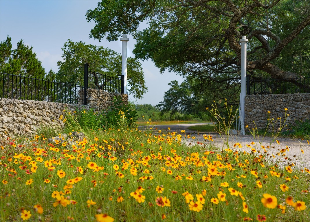 892 Baird Ranch Road Johnson City, TX 78636 - Photo 7 of 22 View of property entry featuring asphalt driveway and fence