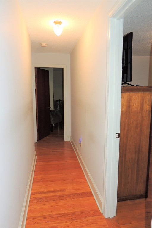 52 Carnavon Circle Springfield, MA 01109 - Photo 8 of 16 a view of a hallway with wooden floor and a bathroom