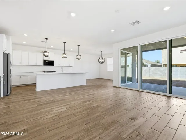 a kitchen with a sink a chandelier and wooden floor