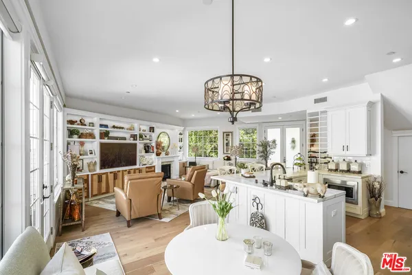 a view of a dining room and livingroom with furniture wooden floor a chandelier