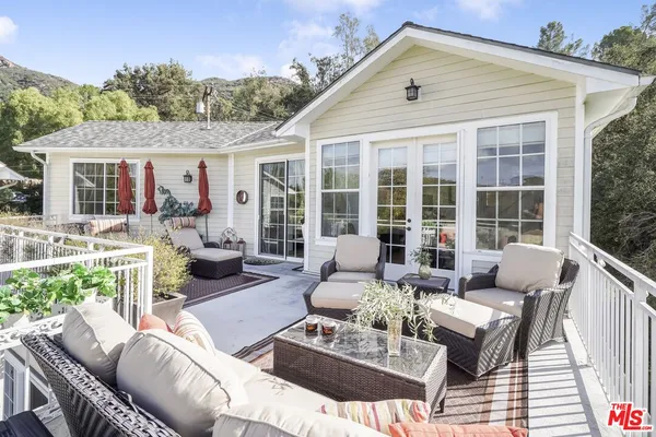 a view of a patio with couches chairs and wooden floor