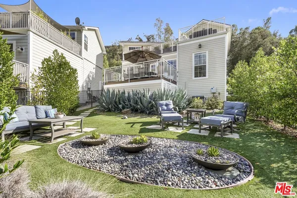 a view of a house with backyard and sitting area