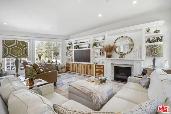 a living room with furniture a fireplace and a large window