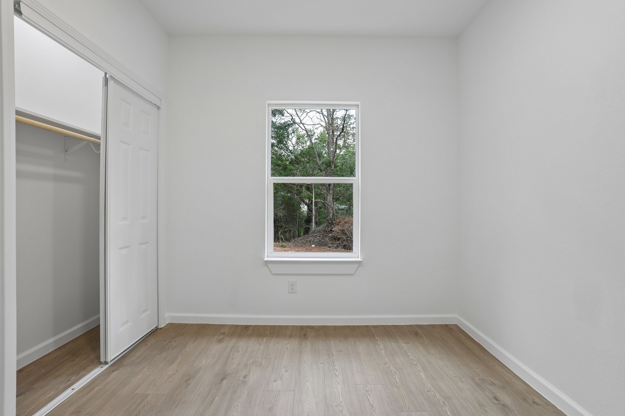 210 Flint Ridge Street Bastrop, TX 78602 - Photo 16 of 40 a view of an empty room with wooden floor and a window