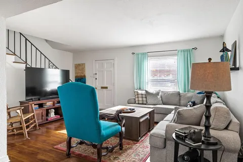 a living room with furniture a flat screen tv and a window