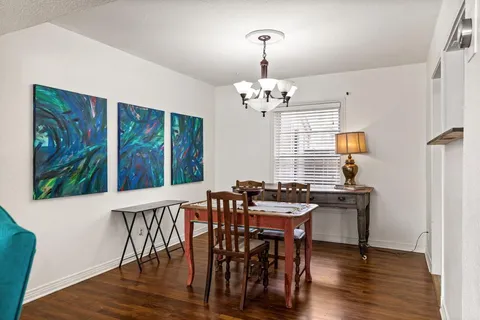 a view of a dining room with furniture wooden floor and chandelier