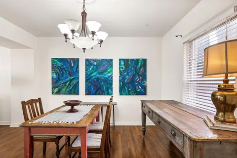 a view of a dining room with furniture wooden floor and chandelier
