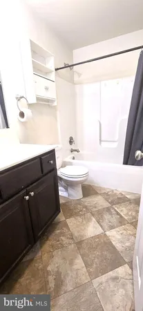 a bathroom with a sink a toilet a tub and shower