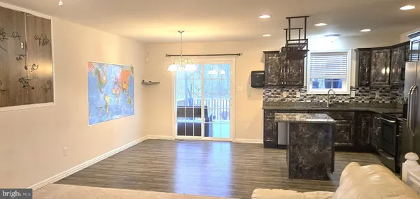 a open kitchen view with fireplace and wooden floor