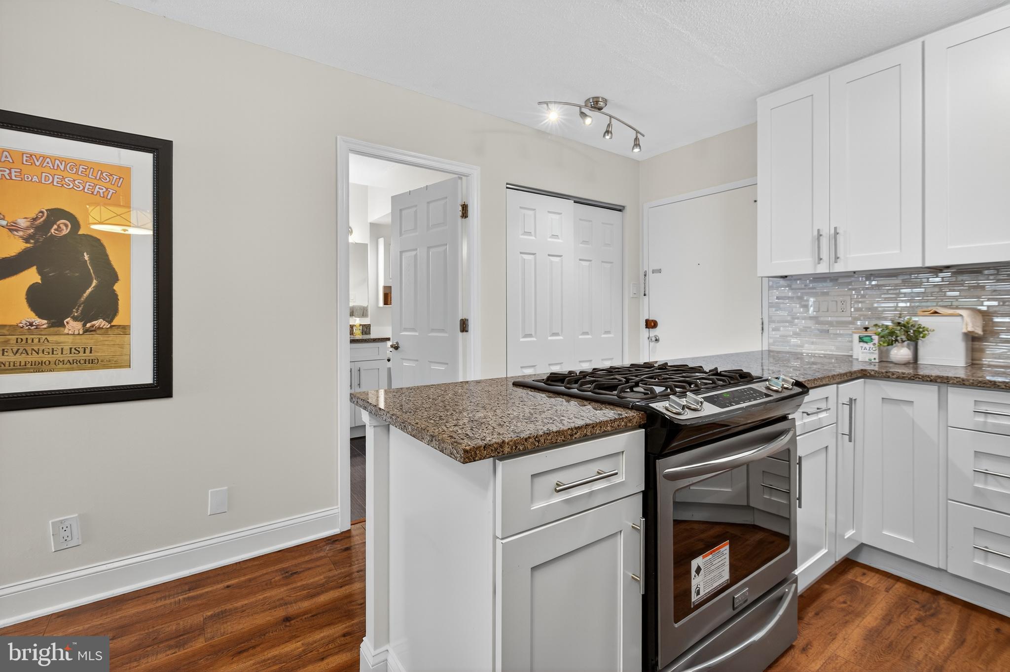 2201 L Street Northwest, Unit 316 Washington, DC 20037 - Photo 14 of 20 a kitchen with granite countertop a stove and a sink