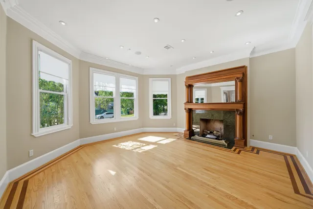 a view of an empty room with a window and fireplace