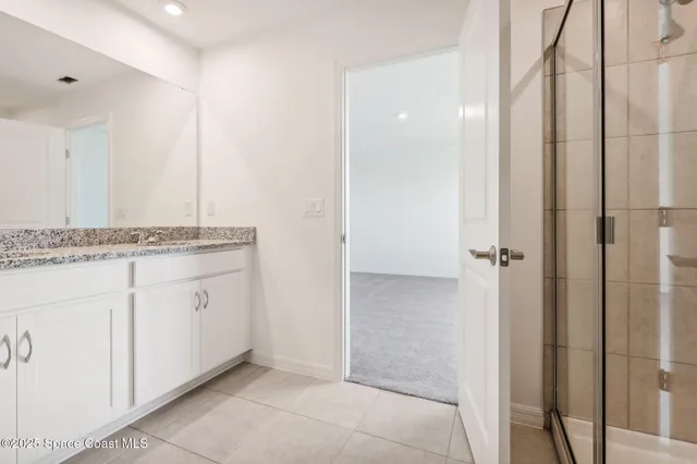 a spacious bathroom with a granite countertop sink and a mirror