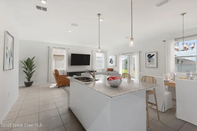 a living room with furniture a flat screen tv and a view of kitchen