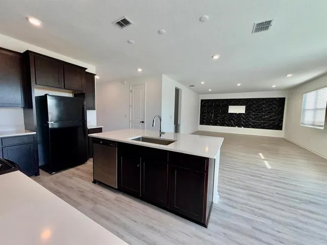 a kitchen with stainless steel appliances granite countertop a refrigerator and a sink