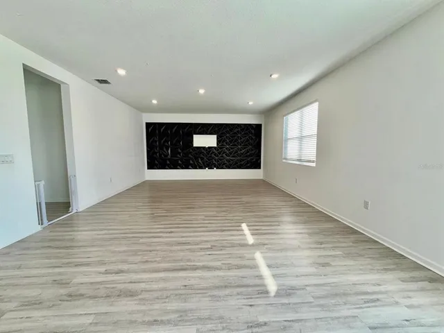 a view of an empty room with wooden floor