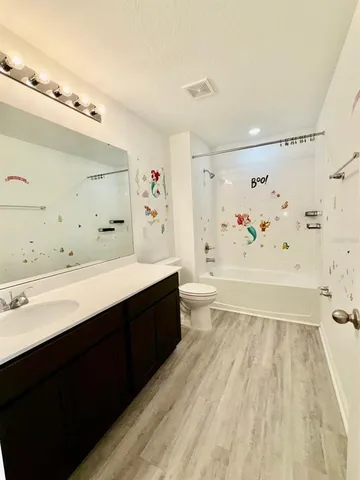 a bathroom with a sink a toilet a shower curtain and a bath tub