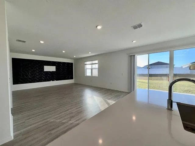 a view of empty room with wooden floor and windows