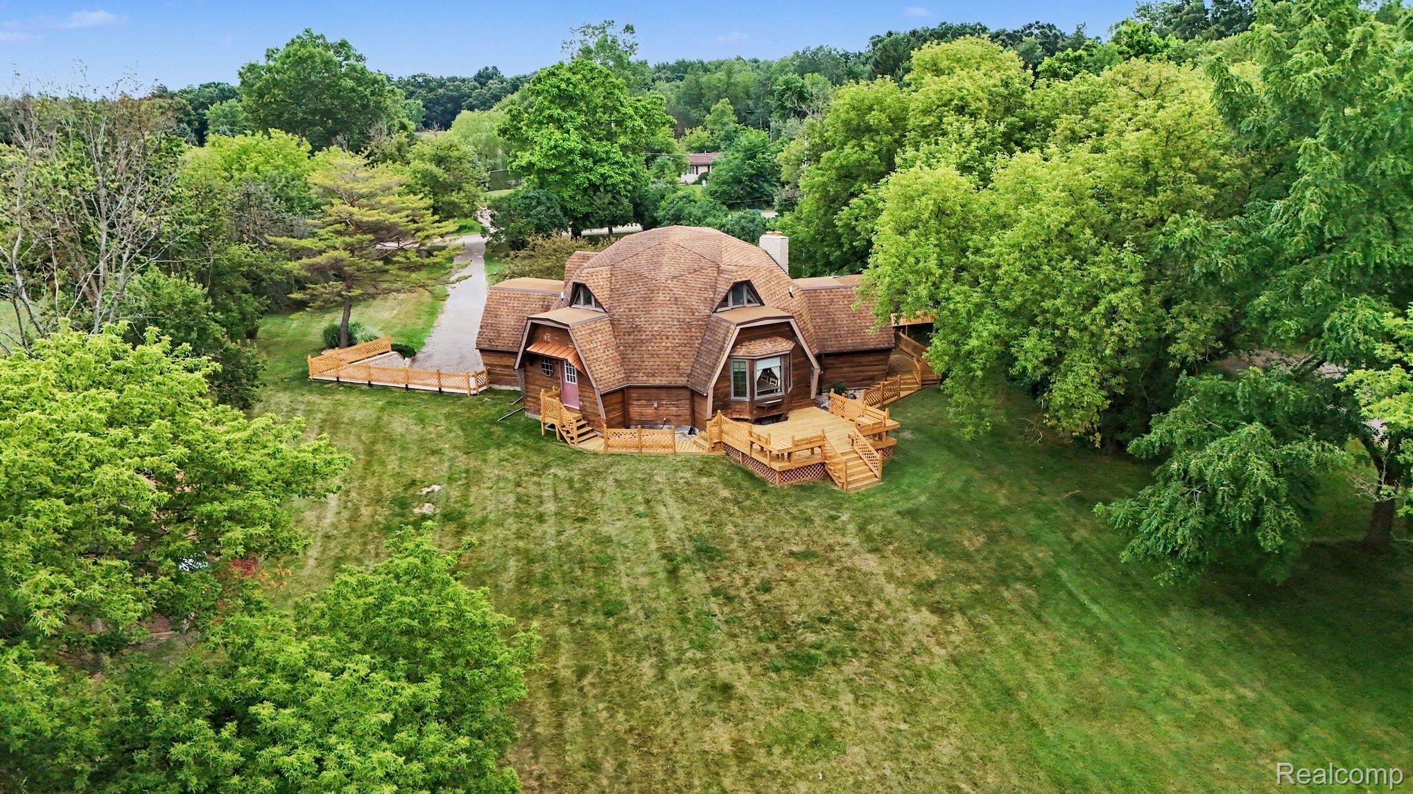 4425 North Henderson Road Davison, MI 48423 - Photo 40 of 43 Geodesic dome residence featuring a multi-level deck, wood siding, and an expansive lawn