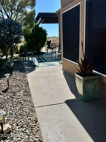 a view of a patio with table and chairs under an umbrella